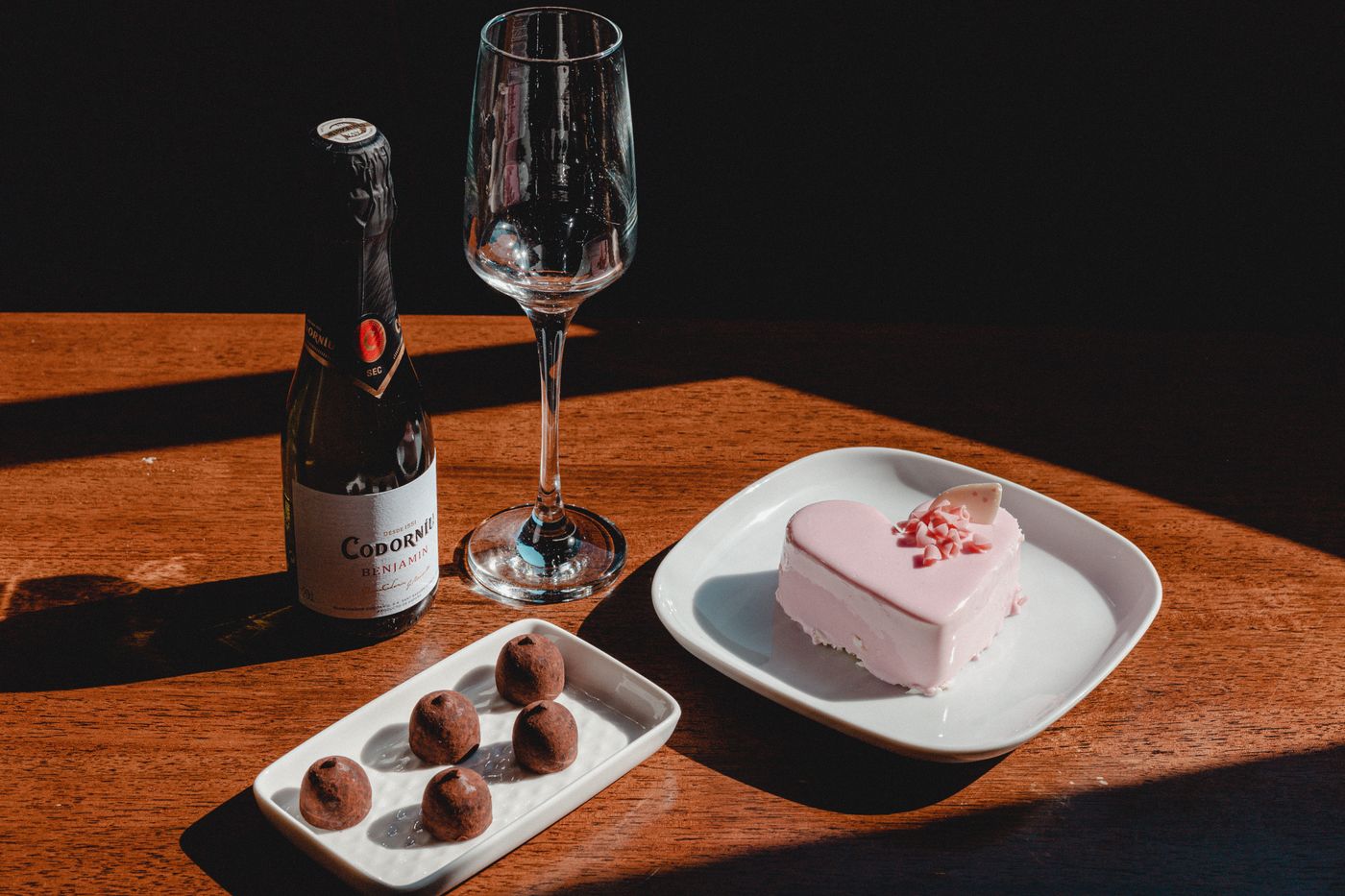 A wine and chocolate pairing flight for date night with several wine glasses and pieces of chocolate from light to dark