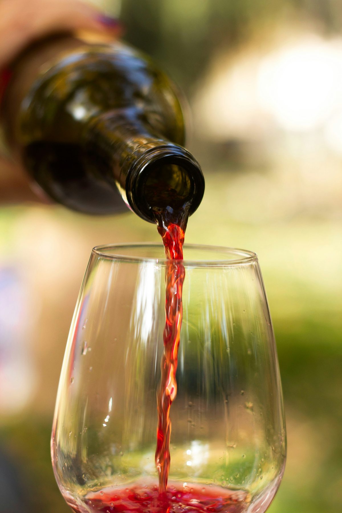 A glass of California Zinfandel red wine being poured