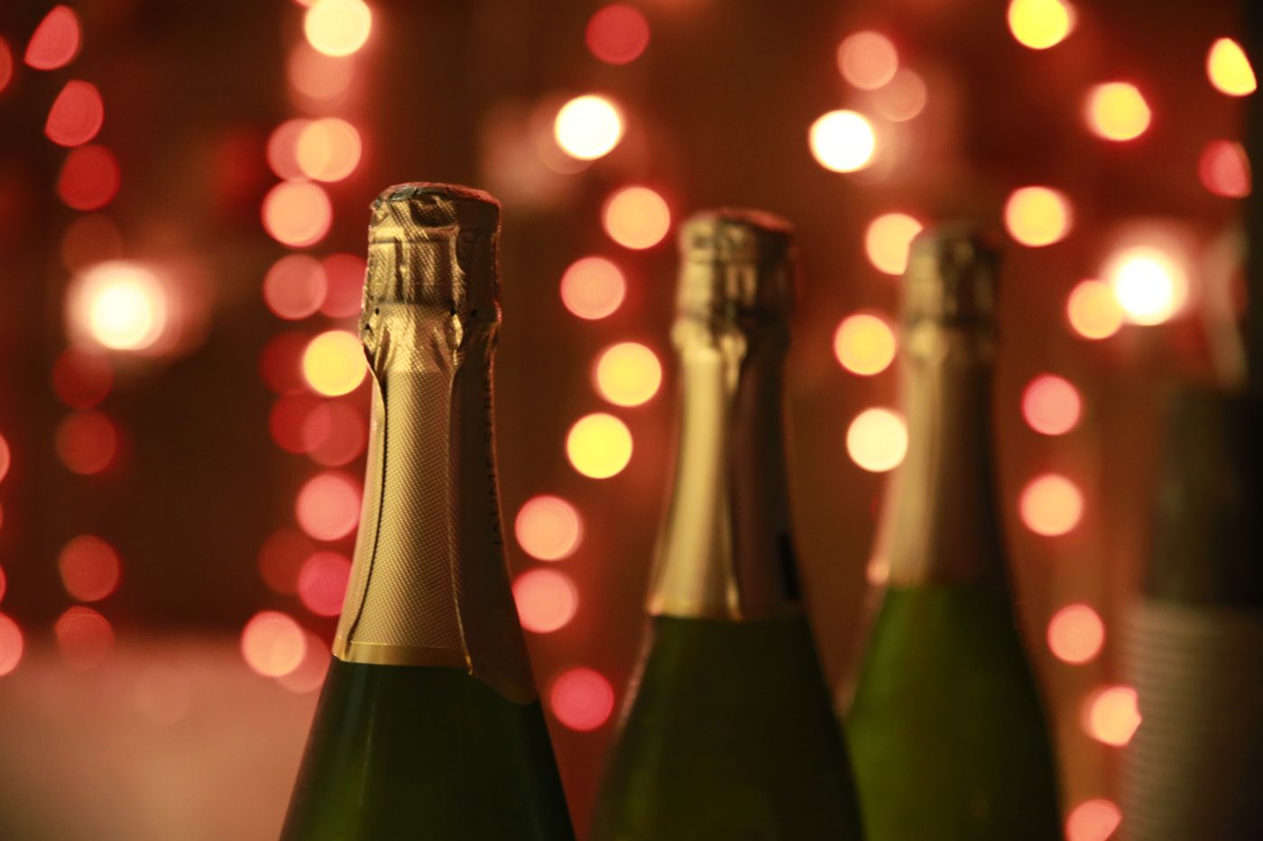 Sparkling wine bottles lit by warm holiday lights for a festive Christmas gift