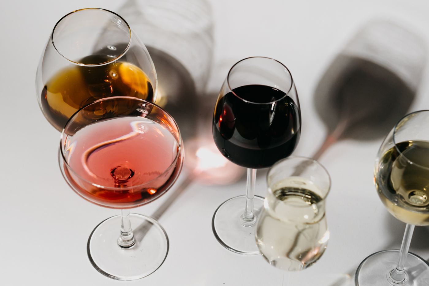 Glasses of red, white, and sparkling wine poured side by side at a party for fifty people