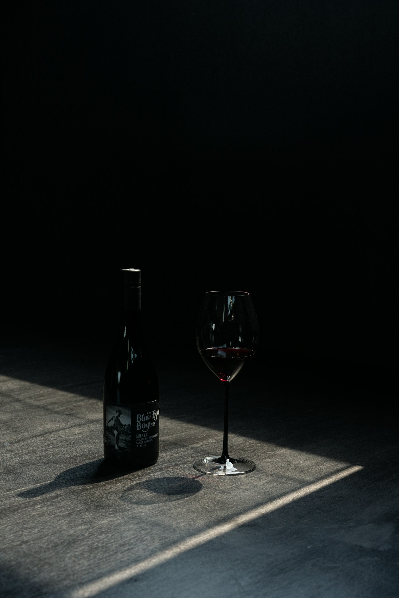 A row of wine bottles in different sizes from a small split up to a large magnum lined up on a table