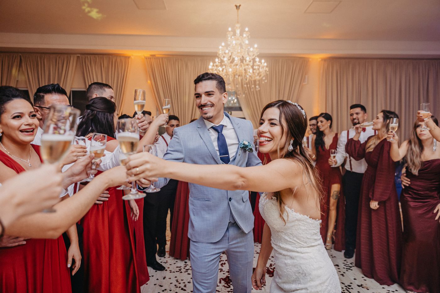 Wedding guests raising sparkling wine flutes for a toast at a reception