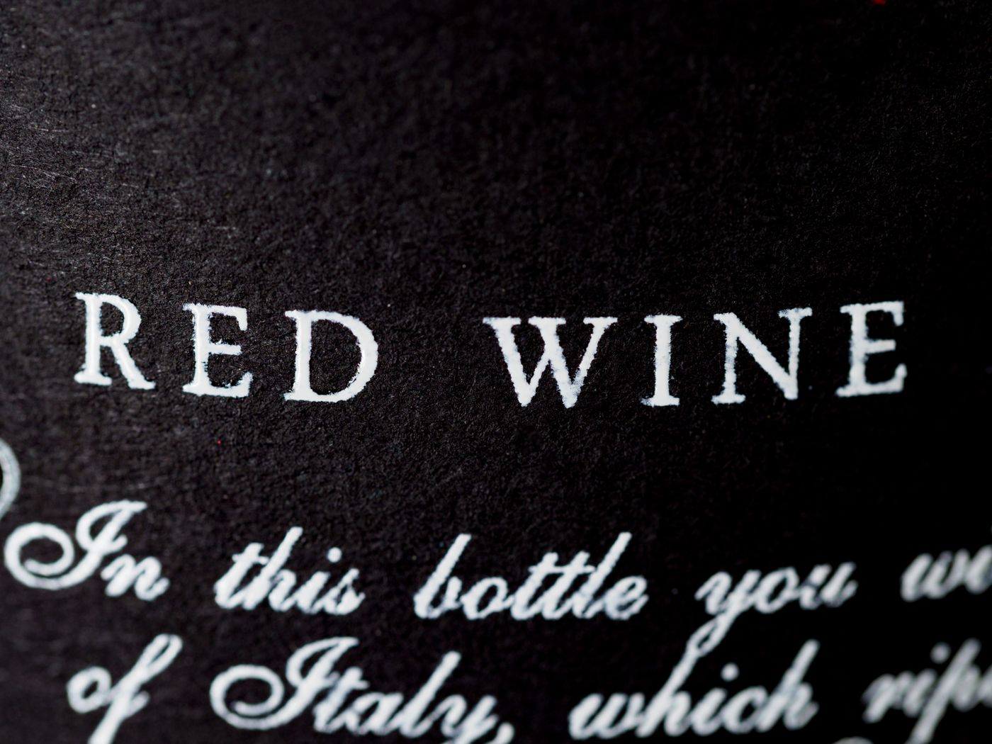Close-up of wine bottle label text, where details like grape, alcohol, and sulfites are printed