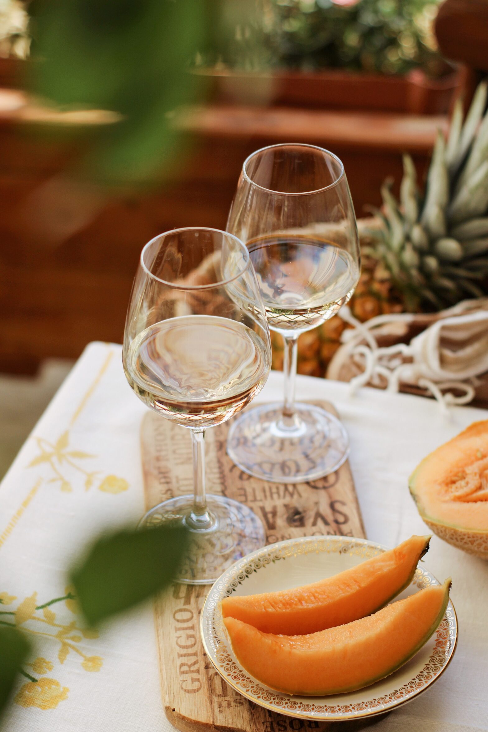 Glasses of chilled Moscato on a table set with fresh fruit and light bites