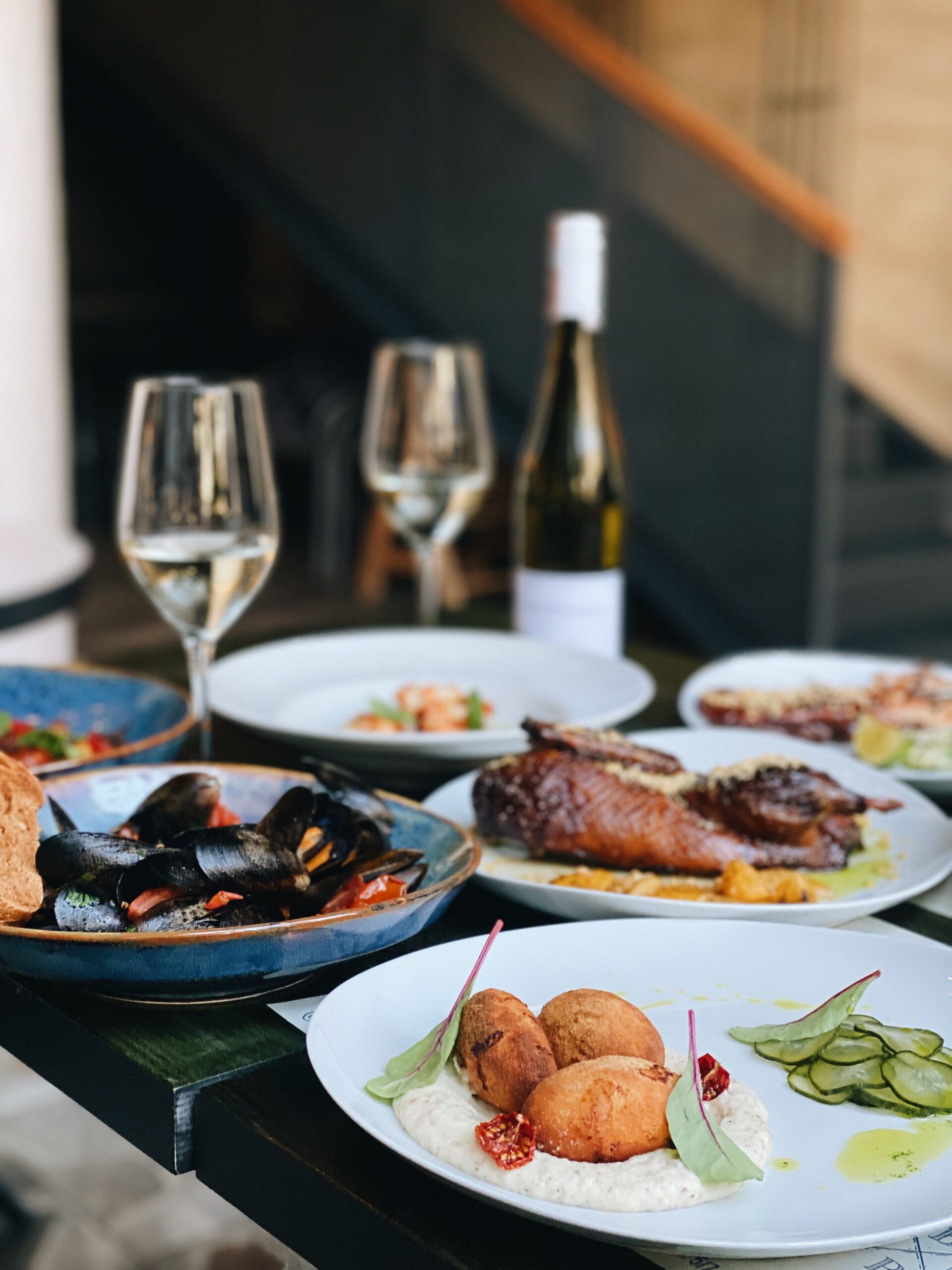 Glasses of Sauvignon Blanc on a table set with seafood and fresh dishes